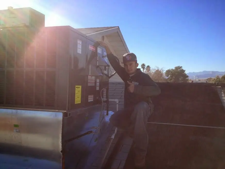 HVAC technician performing Heat Pump Repair on a rooftop unit in Van Buren